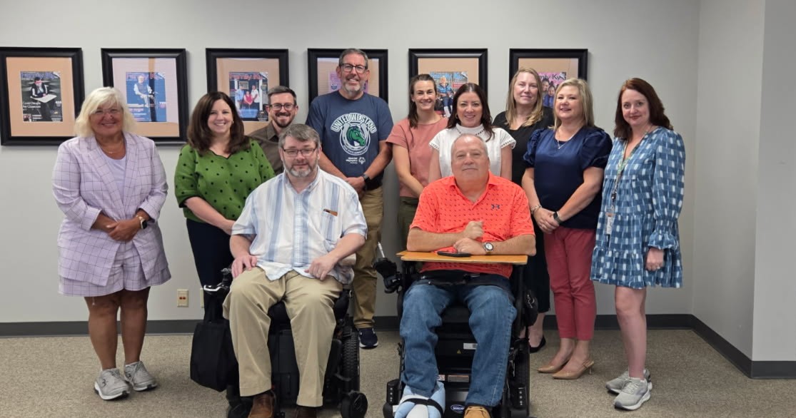 Photo of 7 women and 4 men. 2 of the men are in wheelchairs